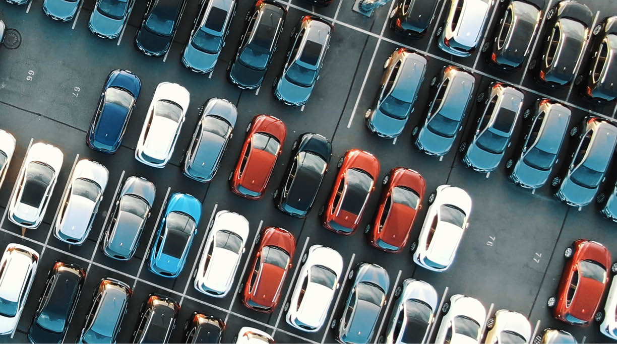 tight coloured finished car rows on warehouse parking area with modern lighting on sunny summer day vertical upper view